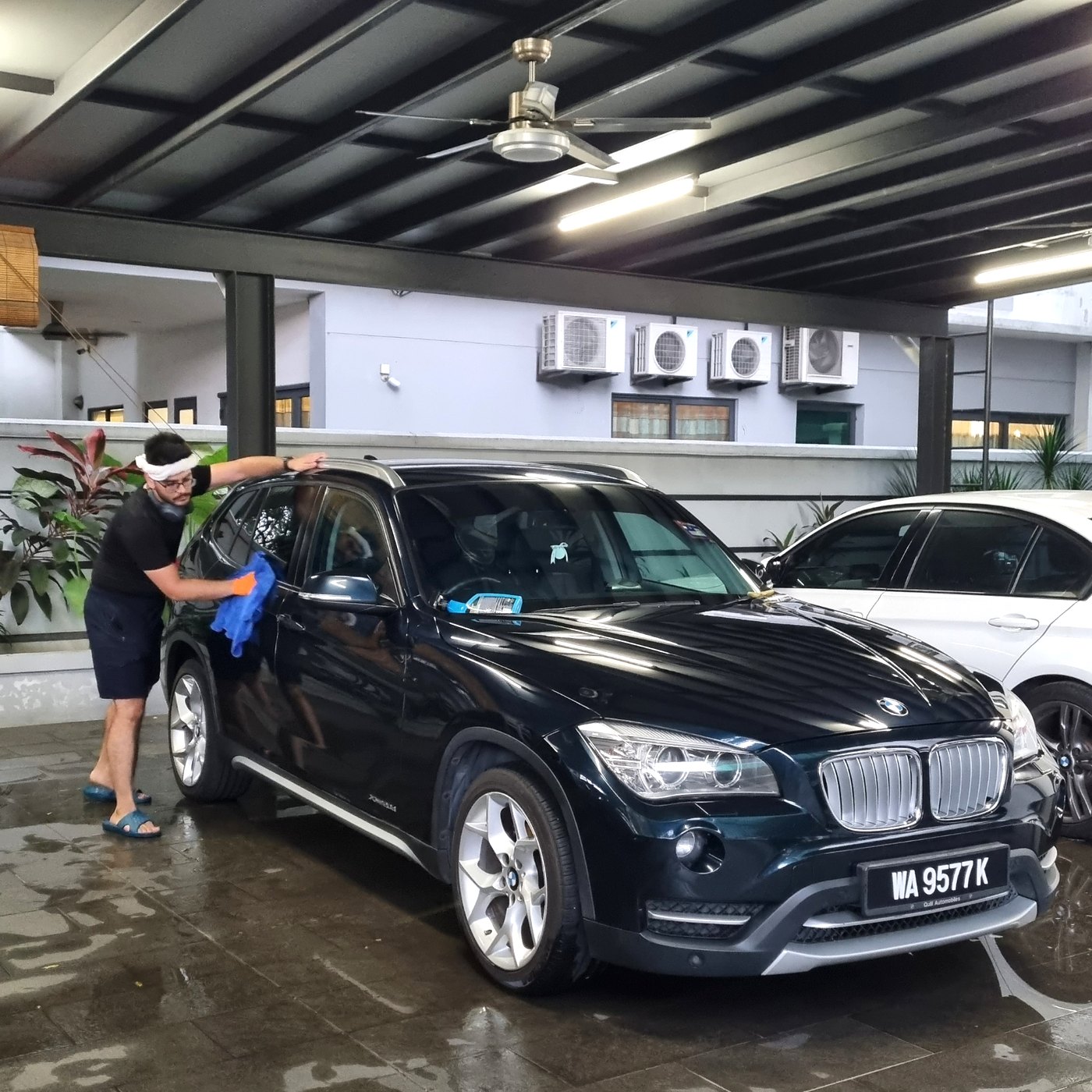 Car being detailed under a home carport