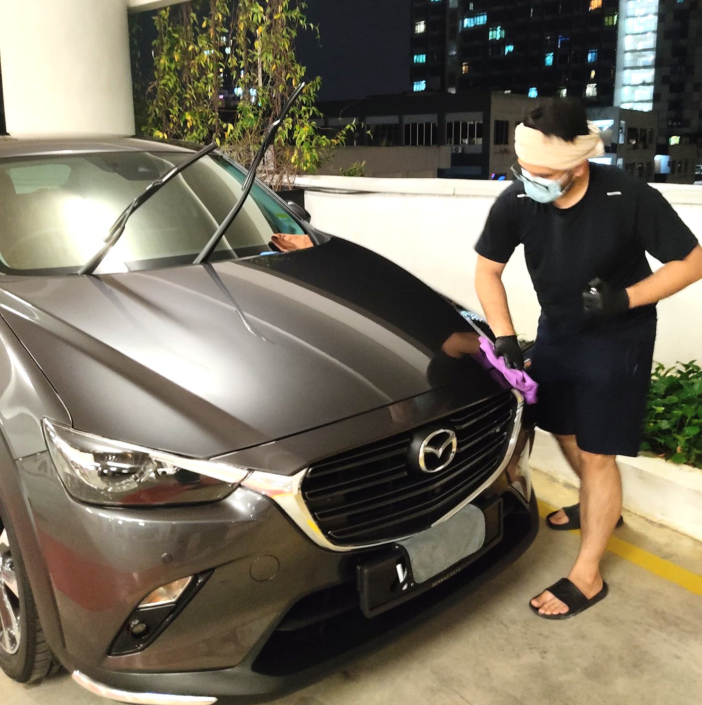 Darius detailing a car at night in a residential car park