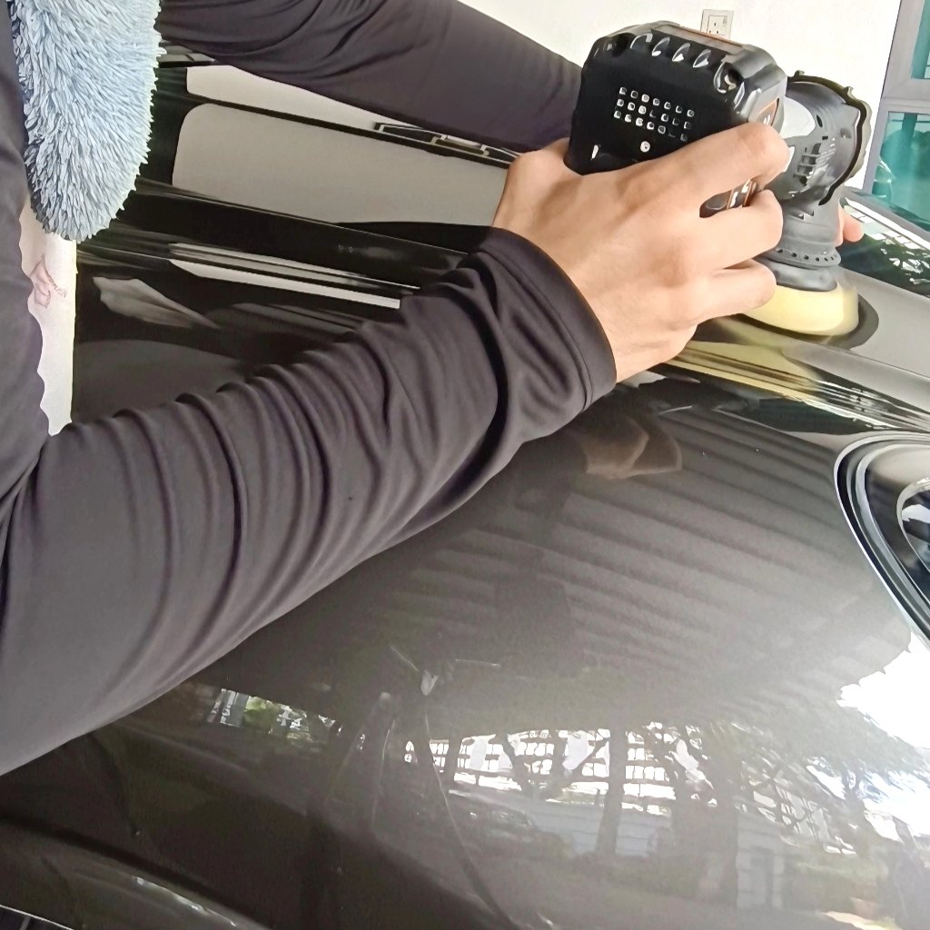 Machine polisher working black paint
